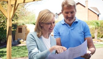 mature-woman-looking-at-design-plan-with-landscape-gardener-picture-id857016850