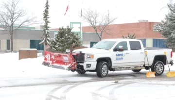MPS snow plow truck clearing snow from a commercial parking lot